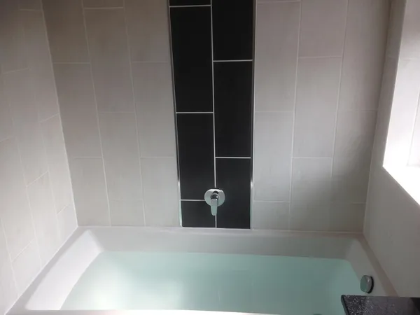 Black tile feature bath installation after Kent