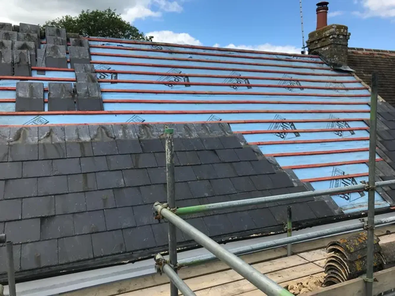 Slate roofing tiles being installed on a roofing project in Kent