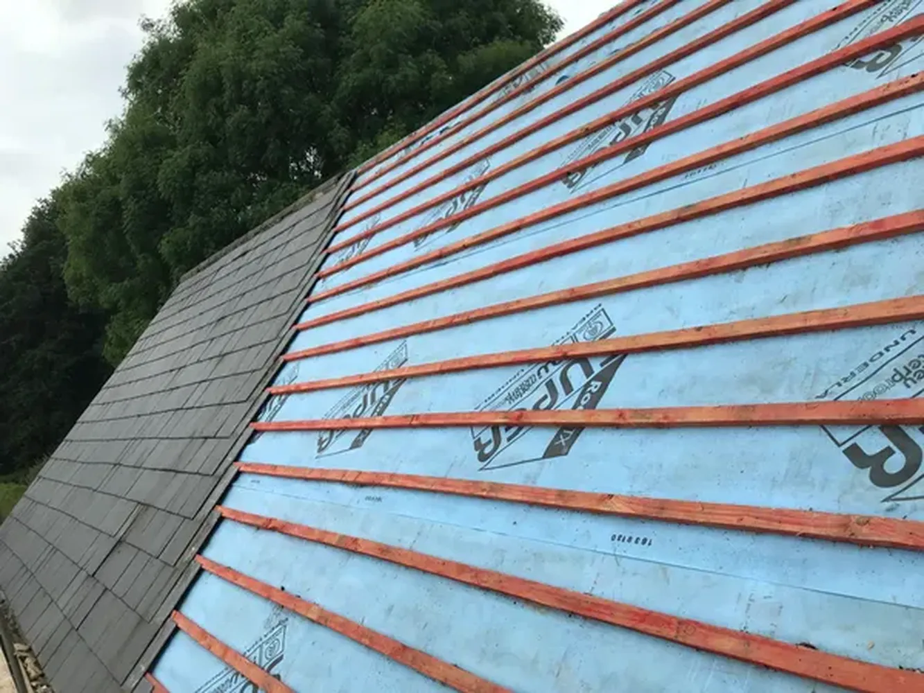 Slate roofing tiles and ridge tiles being installed on a roofing project in Kent