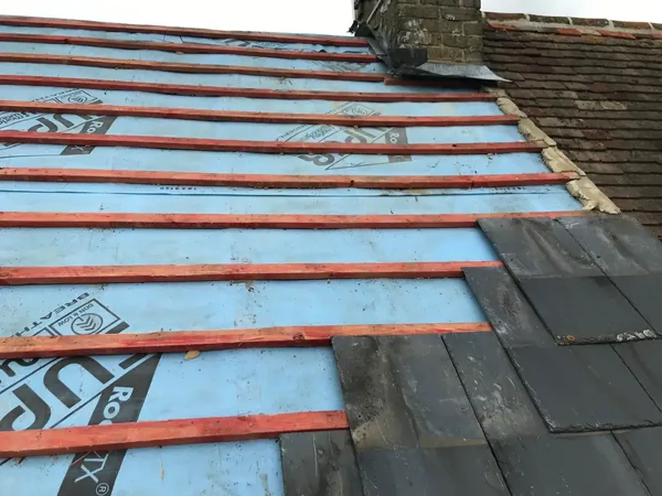 Slate roofing tiles being installed on a roofing project in Kent