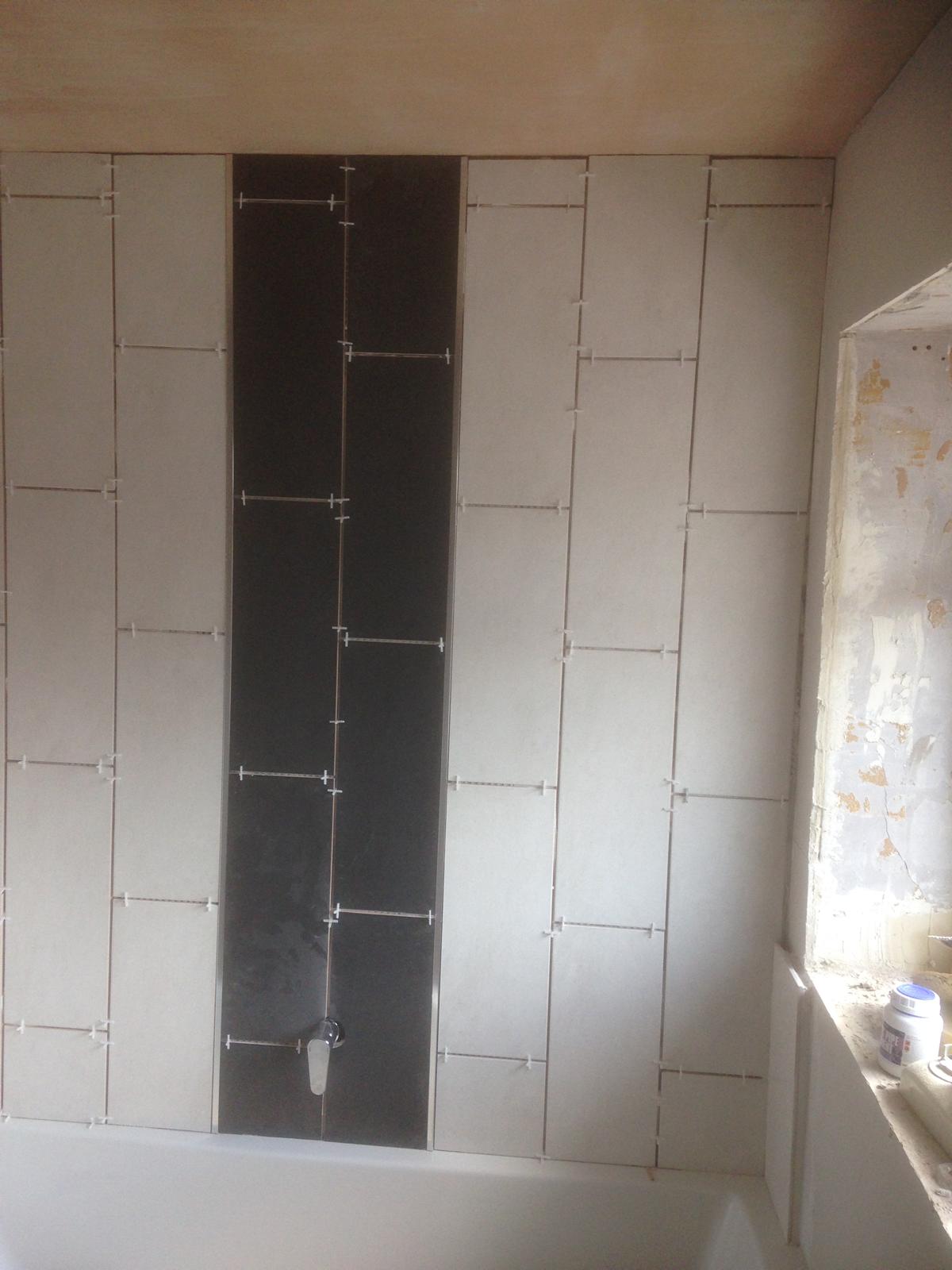 Bathroom black and white wall tile installation ready for grout 