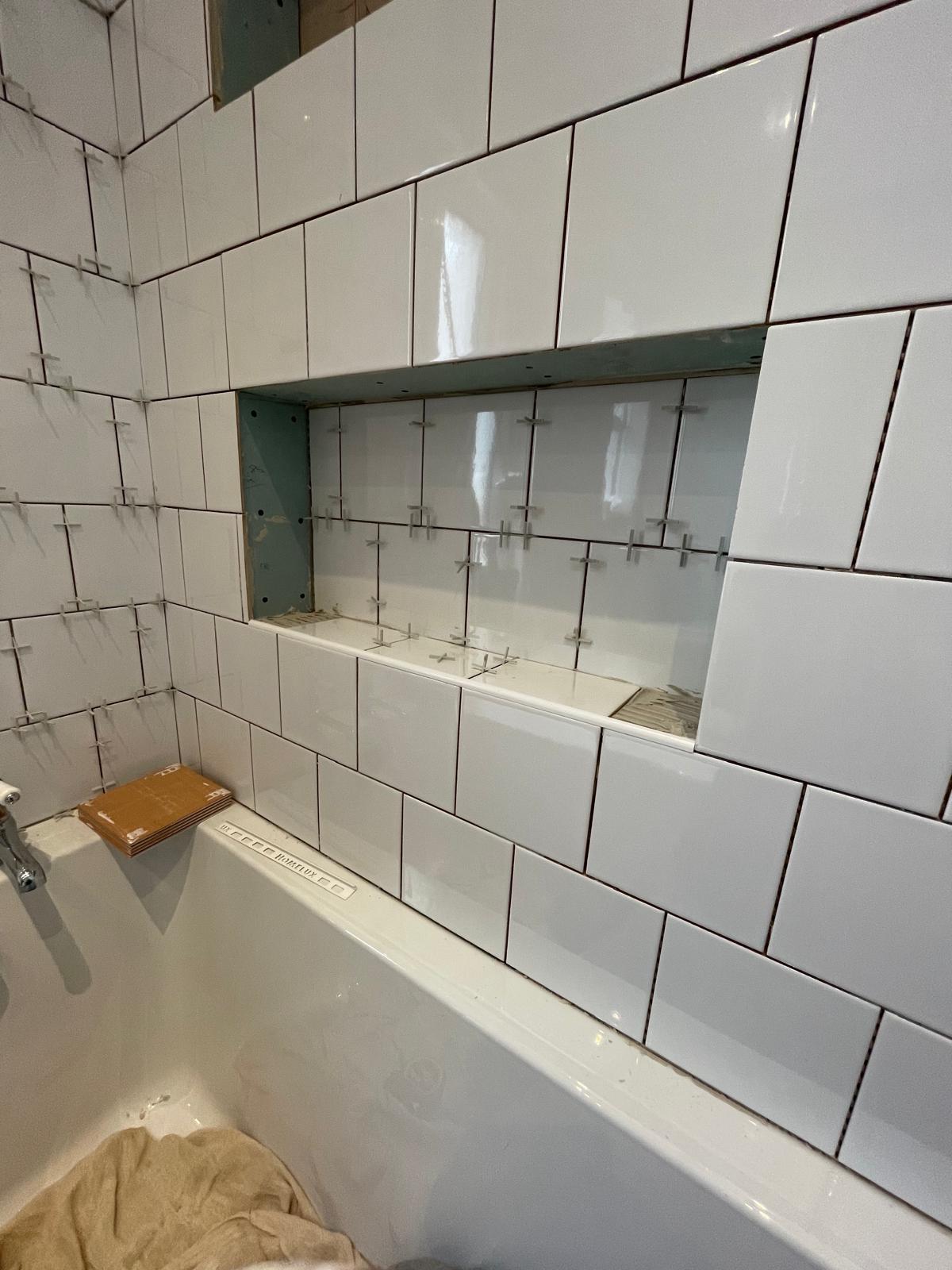 Bathroom in the wall white square tiled shelving area above bath for a bathroom project 