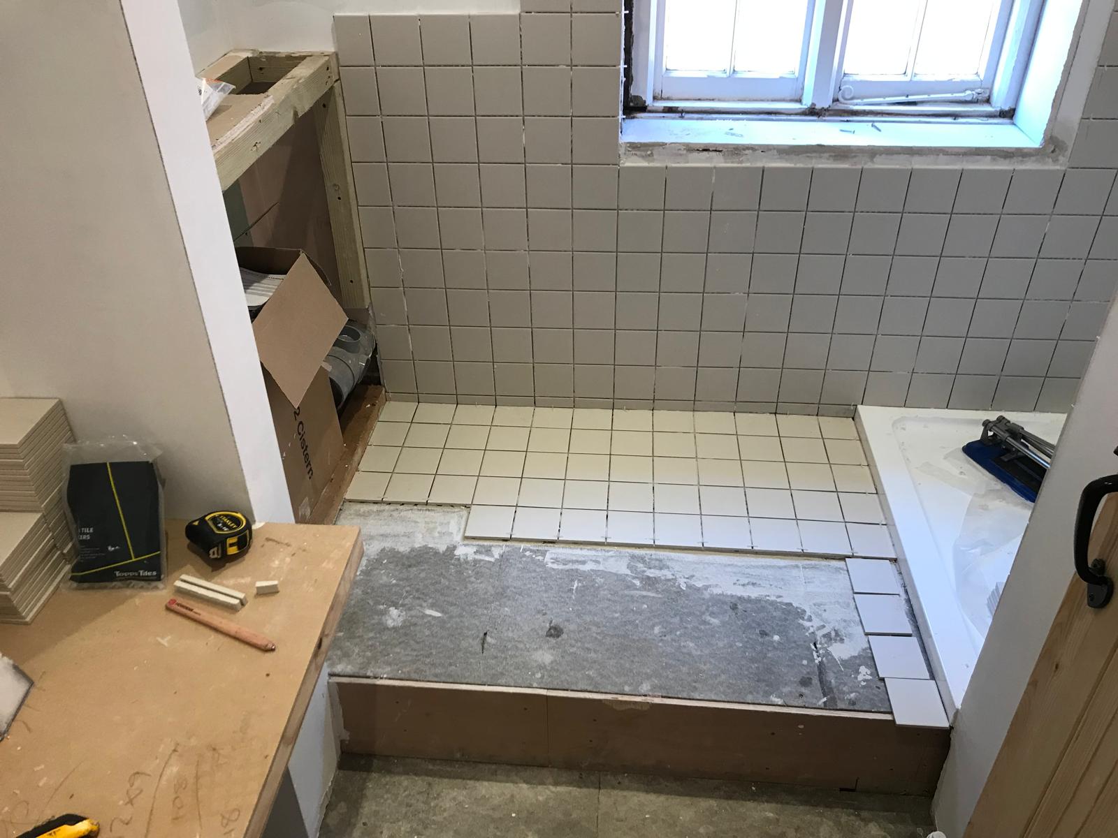 Bathroom project with white floor tile installation 