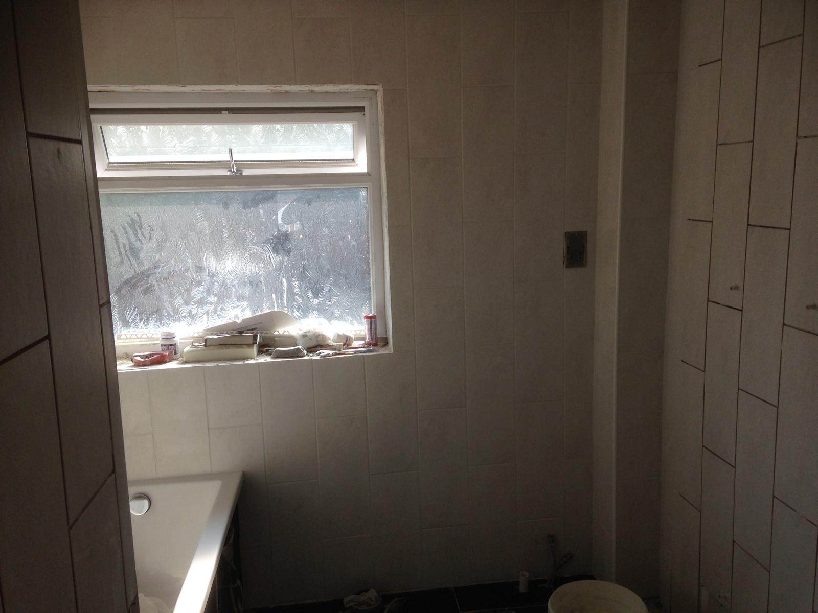 Bathroom refresh project with white wall tile installation 
