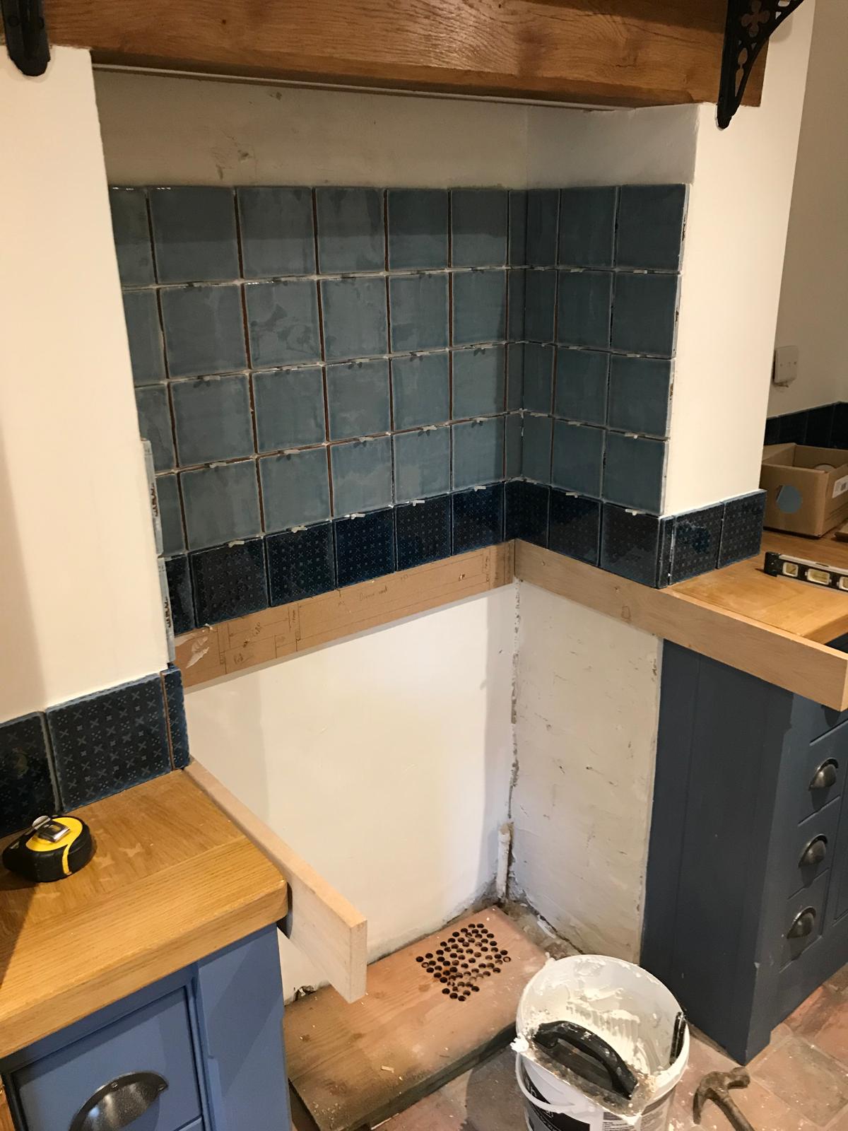 Black and grey square wall tile installation above cooker area for a kitchen project