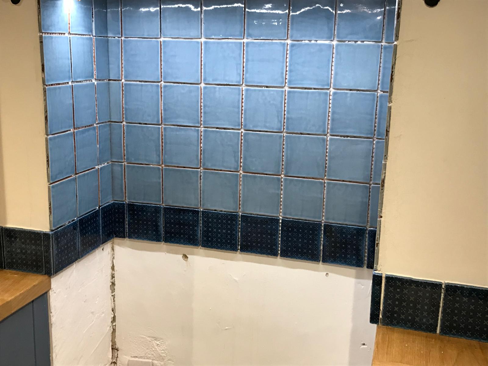 Black and grey wall tile installation with lights for a kitchen project in Kent