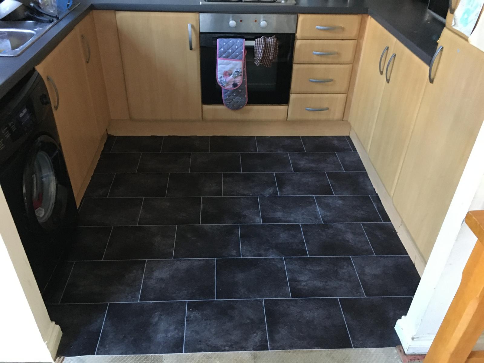 Black floor tile installation for a kitchen