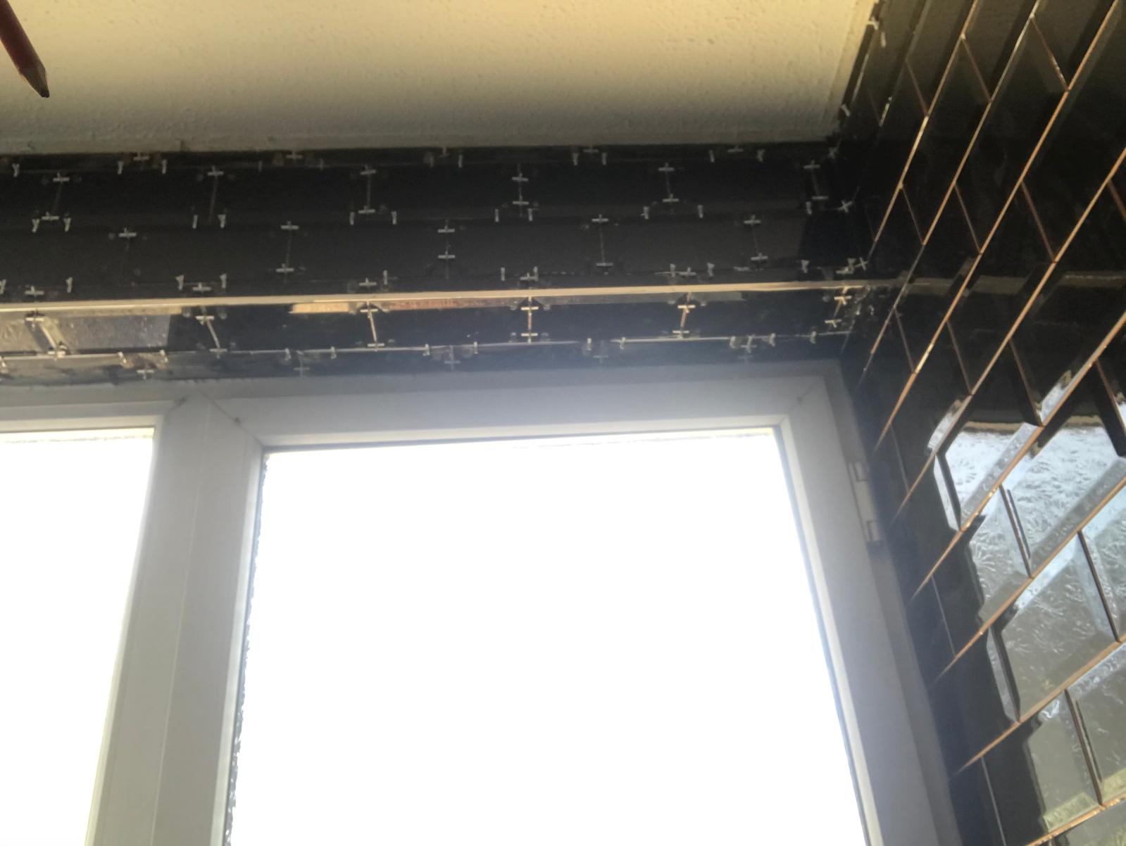 Black gloss wall tile installation on local kitchen project
