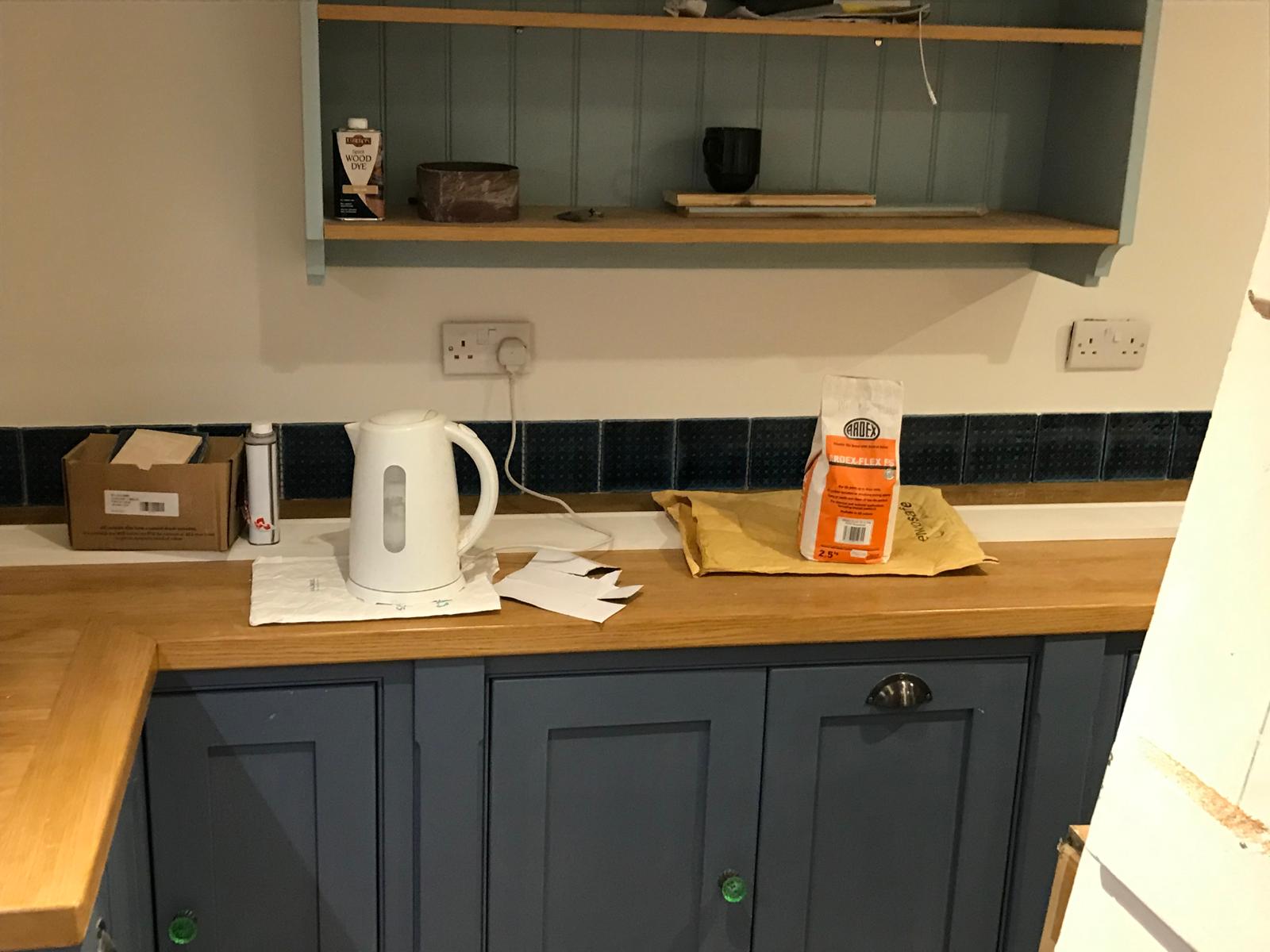 Black tile wall installation along worktop for kitchen project