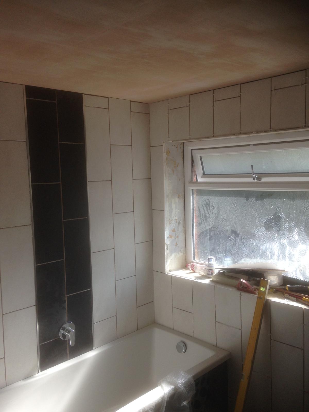 Black wall tile over the bath wall tile installation for a bathroom project in Kent 