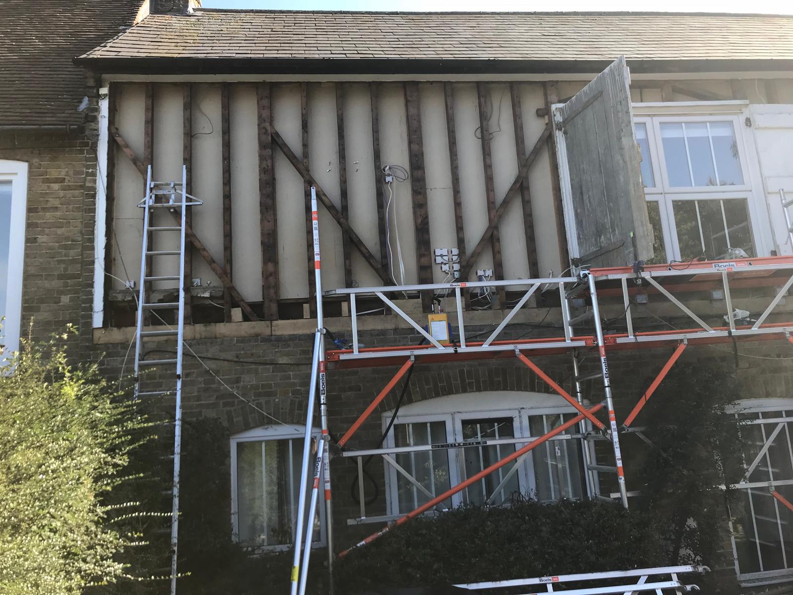 Board installation on exterior of house in preparation of cladding installation