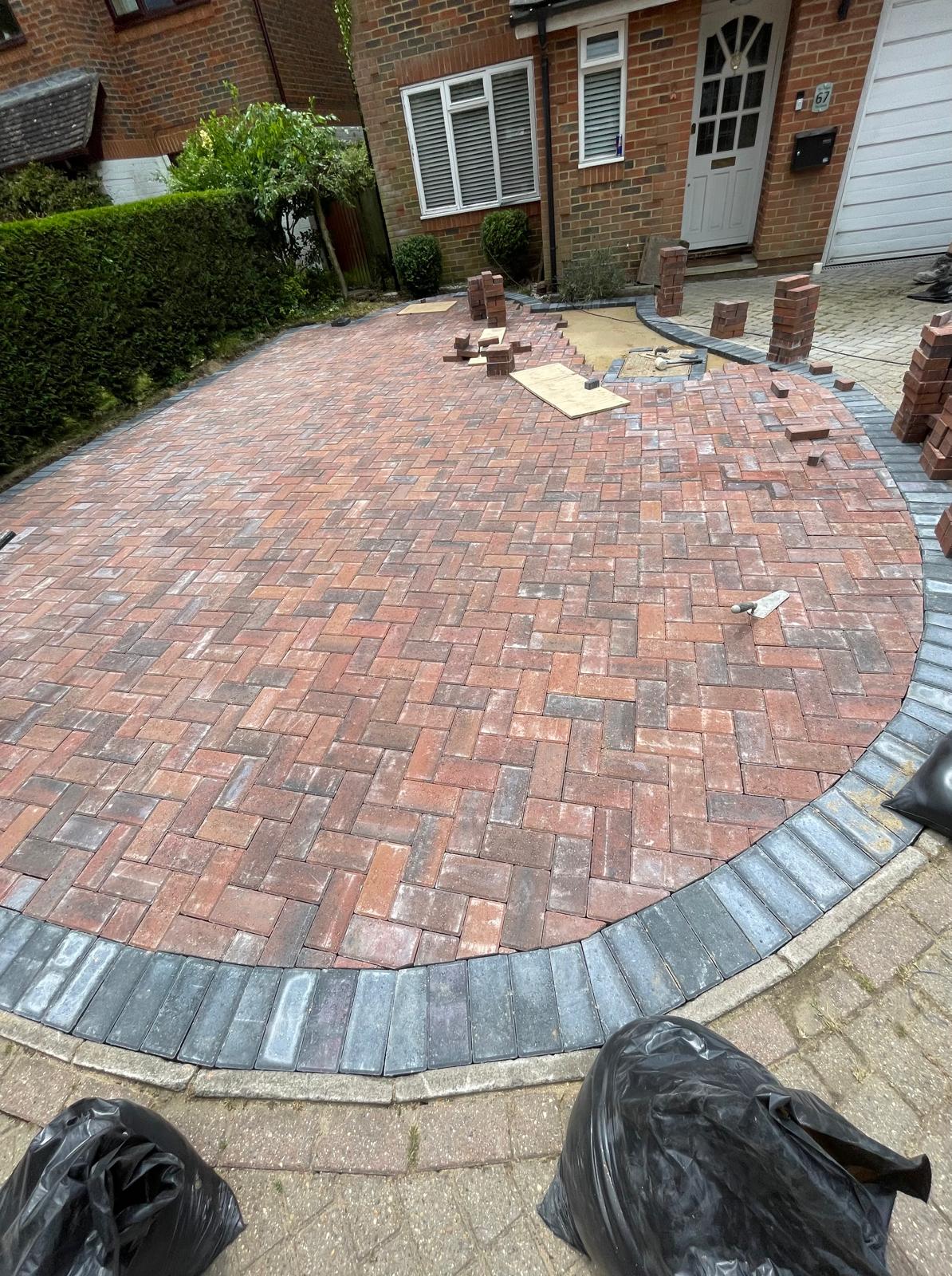 Curved driveway installation with dark grey outer edge for a project in Kent
