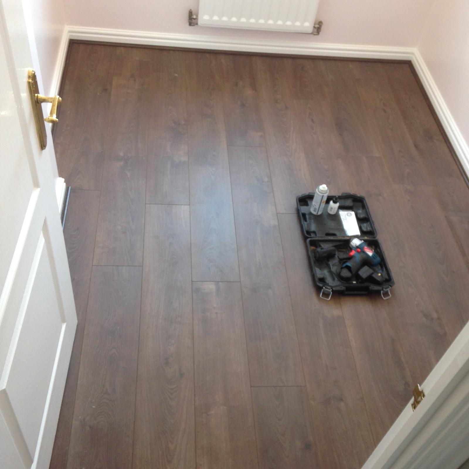 Dark brown laminate floor installation for a local decorating project in Kent