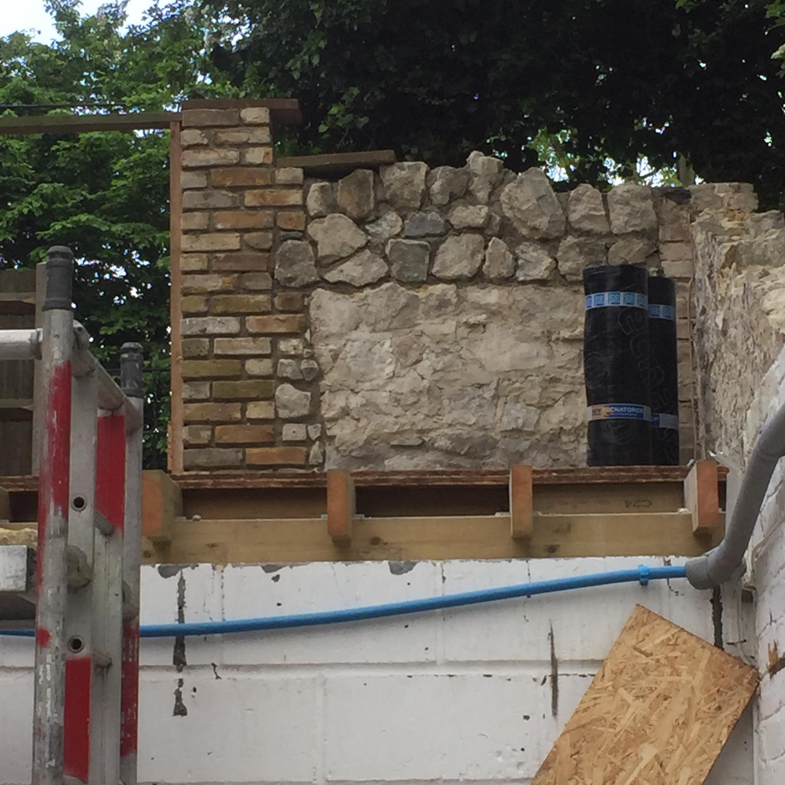 Exterior view of the brick and stone wall installation around the door frame