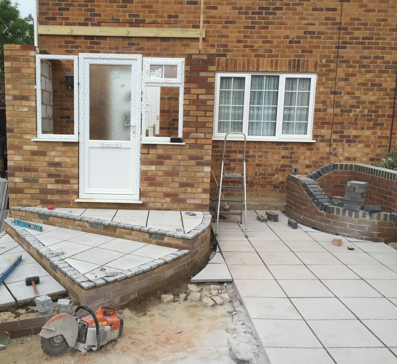 Grey patio installation front of house for local landscaping project