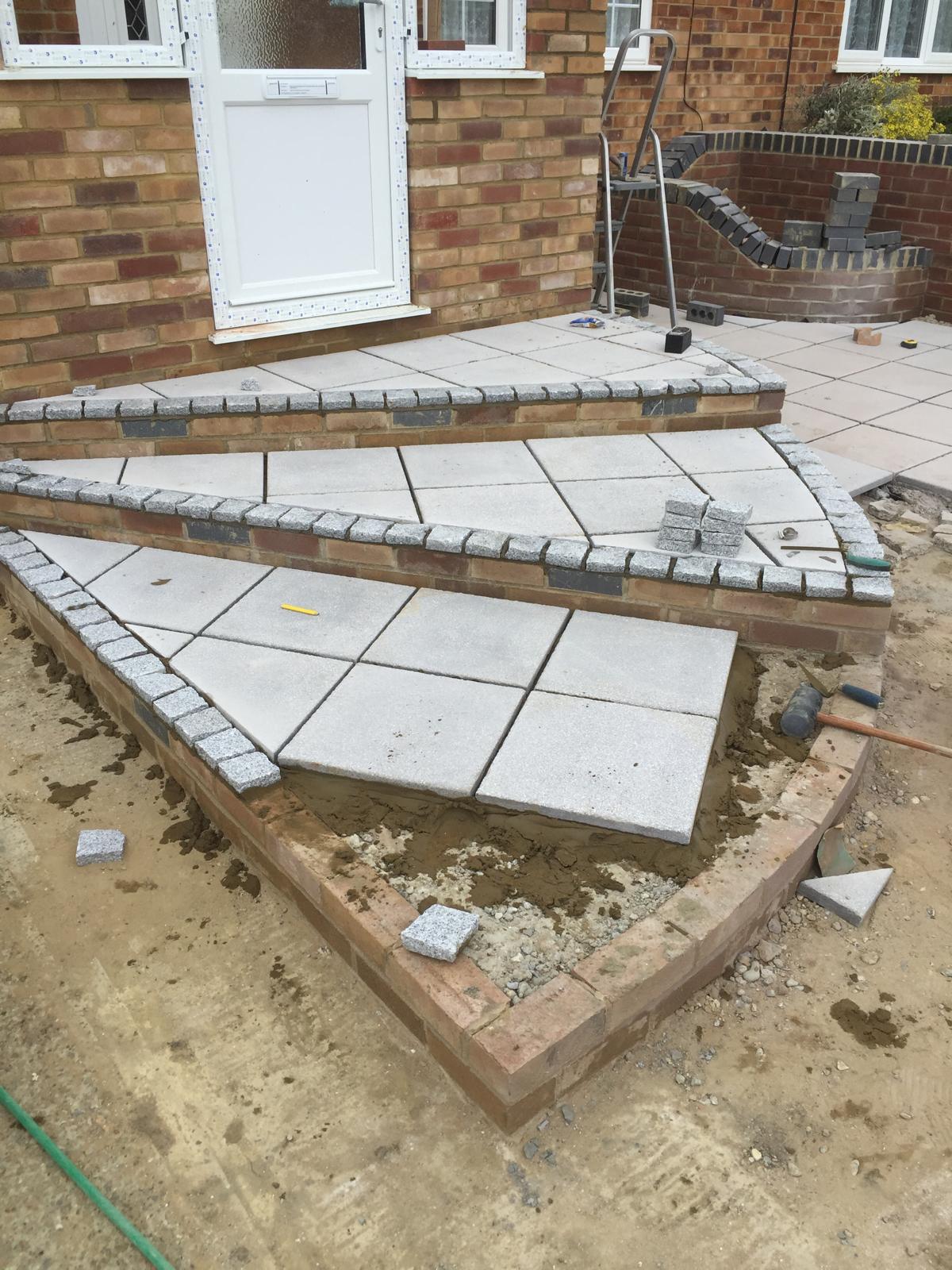 Grey slab installation on curved step area on front of house for local landscaping project