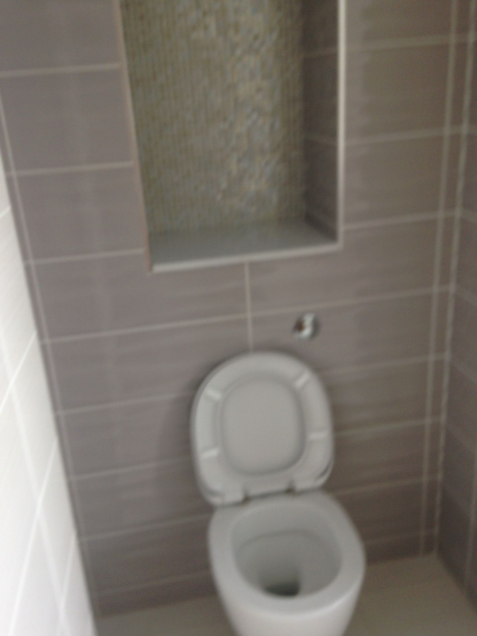 Grey wall tile installation in a toilet area