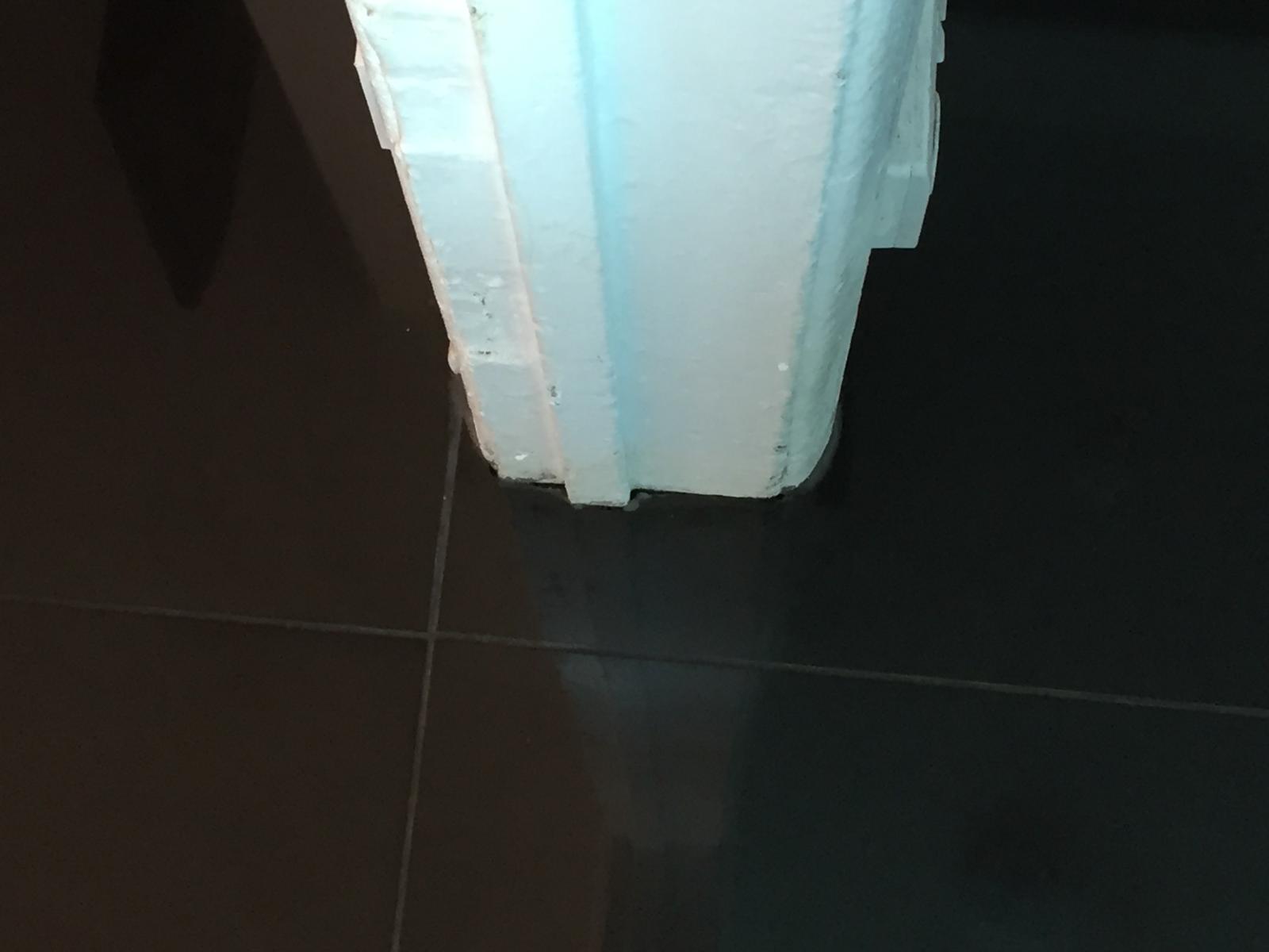 Installation of black gloss porcelain tiles cut round door frame 1