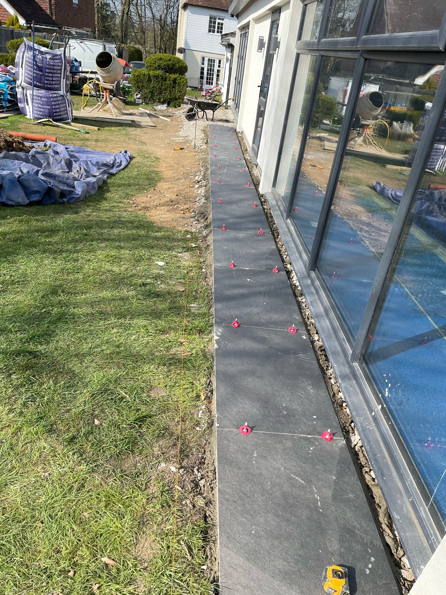 Laying slabs around the sides of the swimming pool building