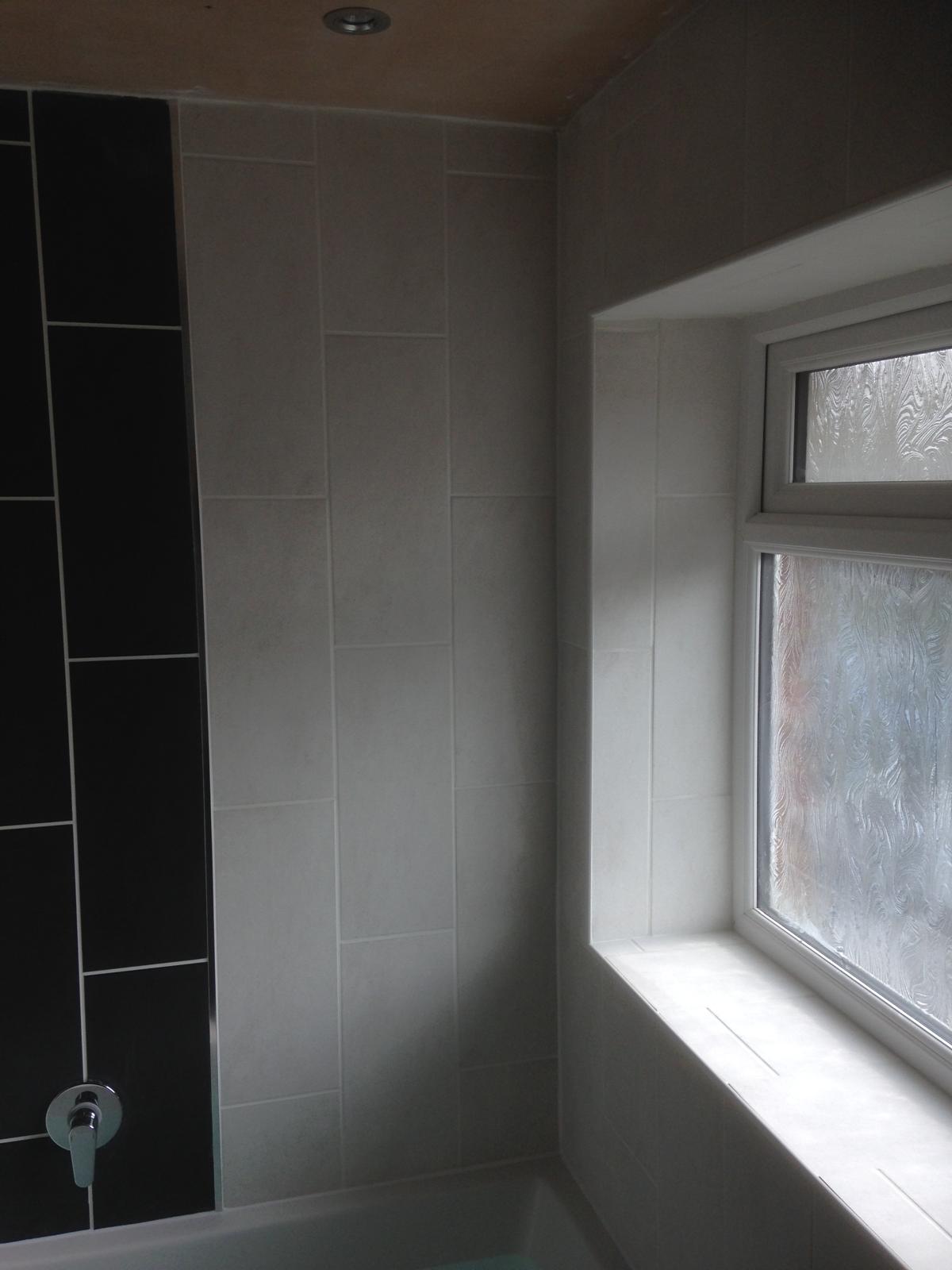 Local bathroom project with white and black wall tiles 