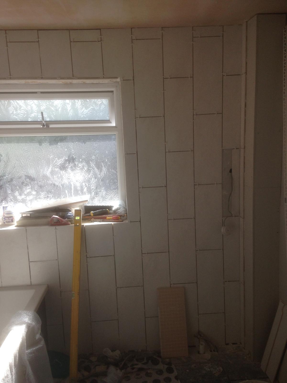 Local bathroom project with white wall tile installation 