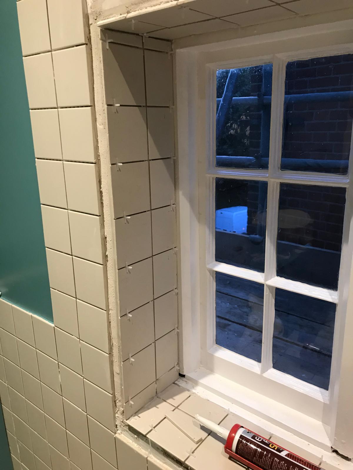 Local bathroom project with white wall tile installation inside window