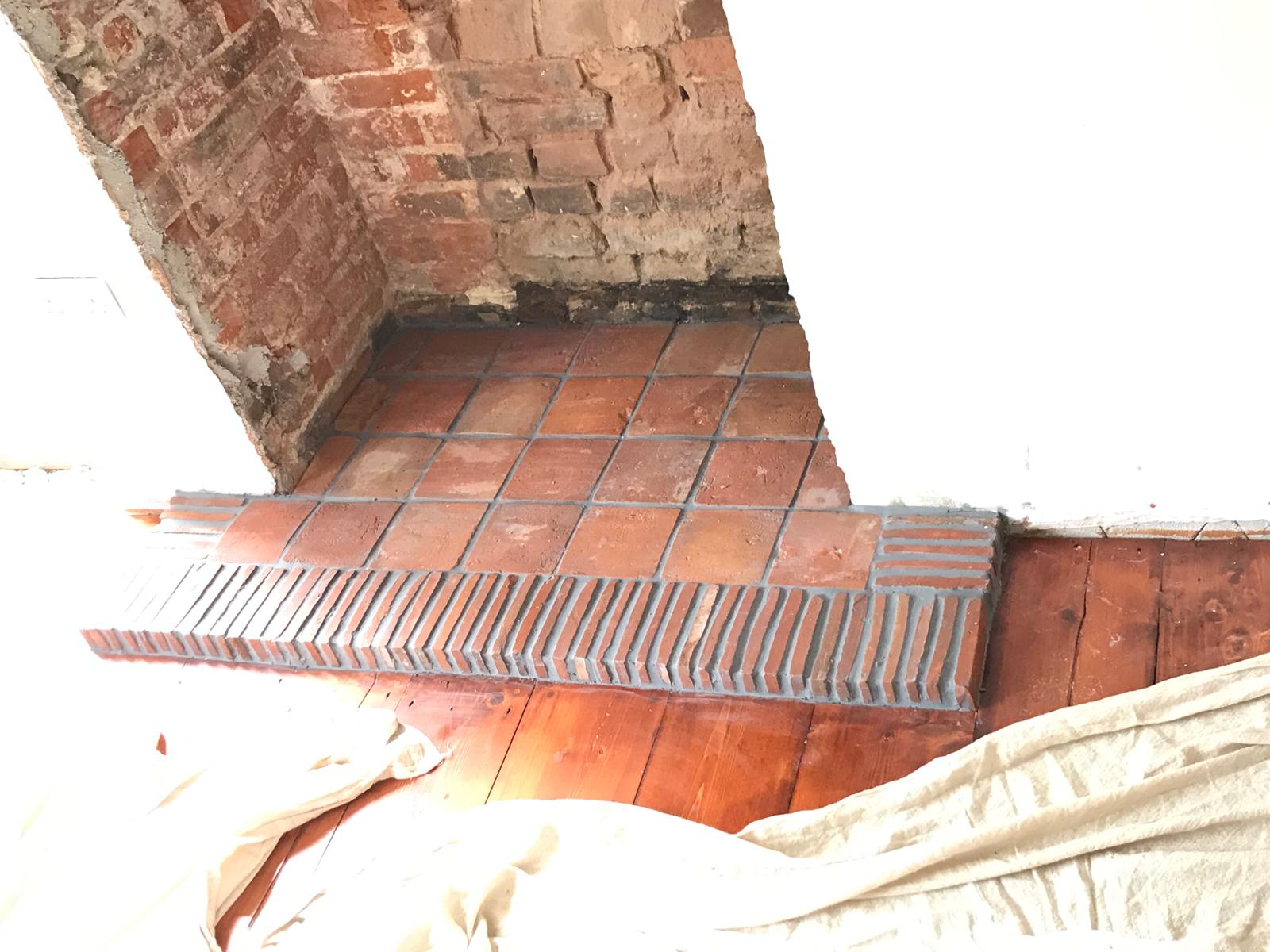 Local decorating project terracotta tile installation in fire place