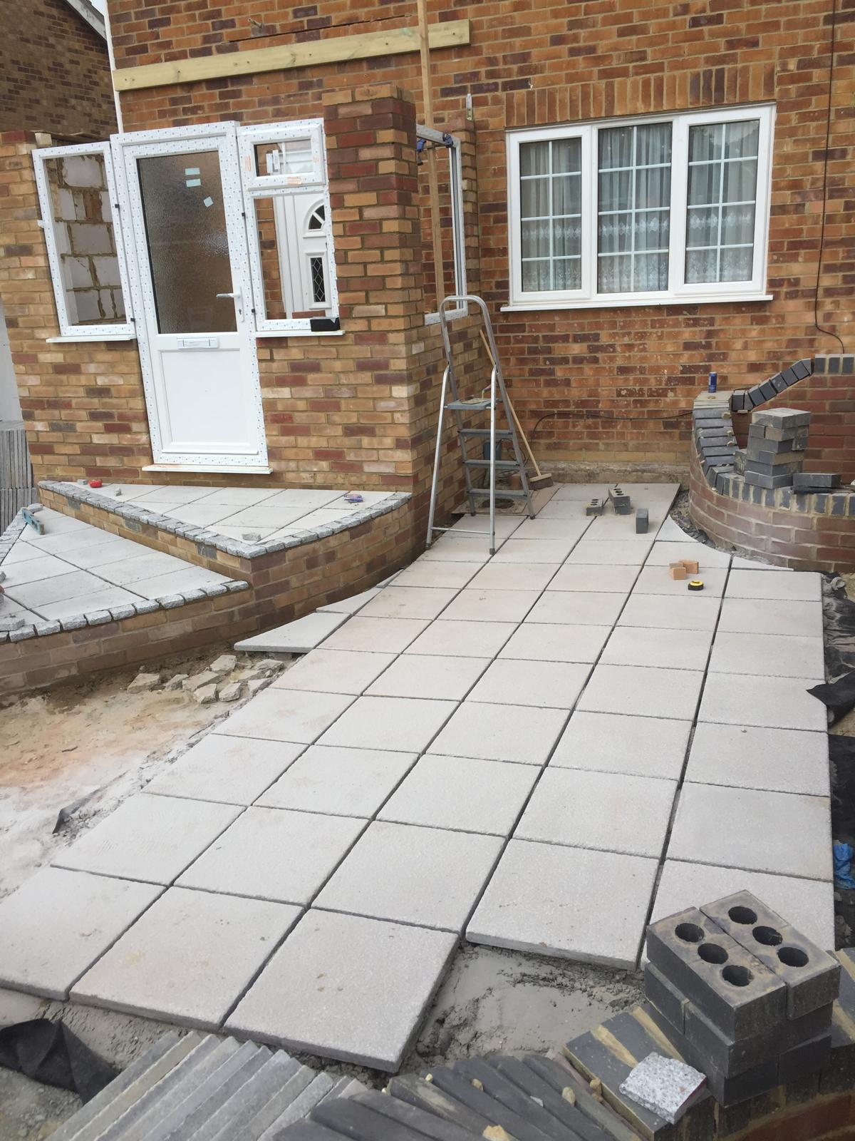 Local landscaping project with front of house grey patio installation