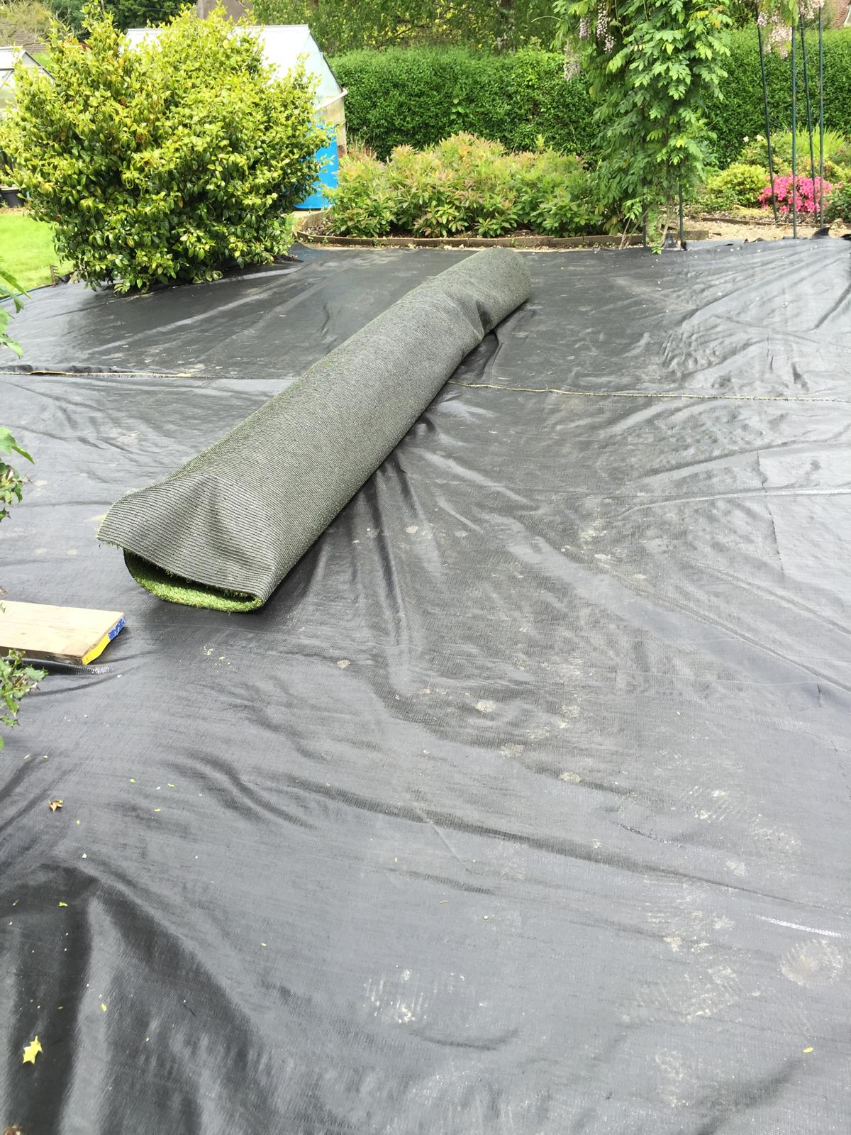 Membrane being laid for ground preparation ready for artificial grass installation