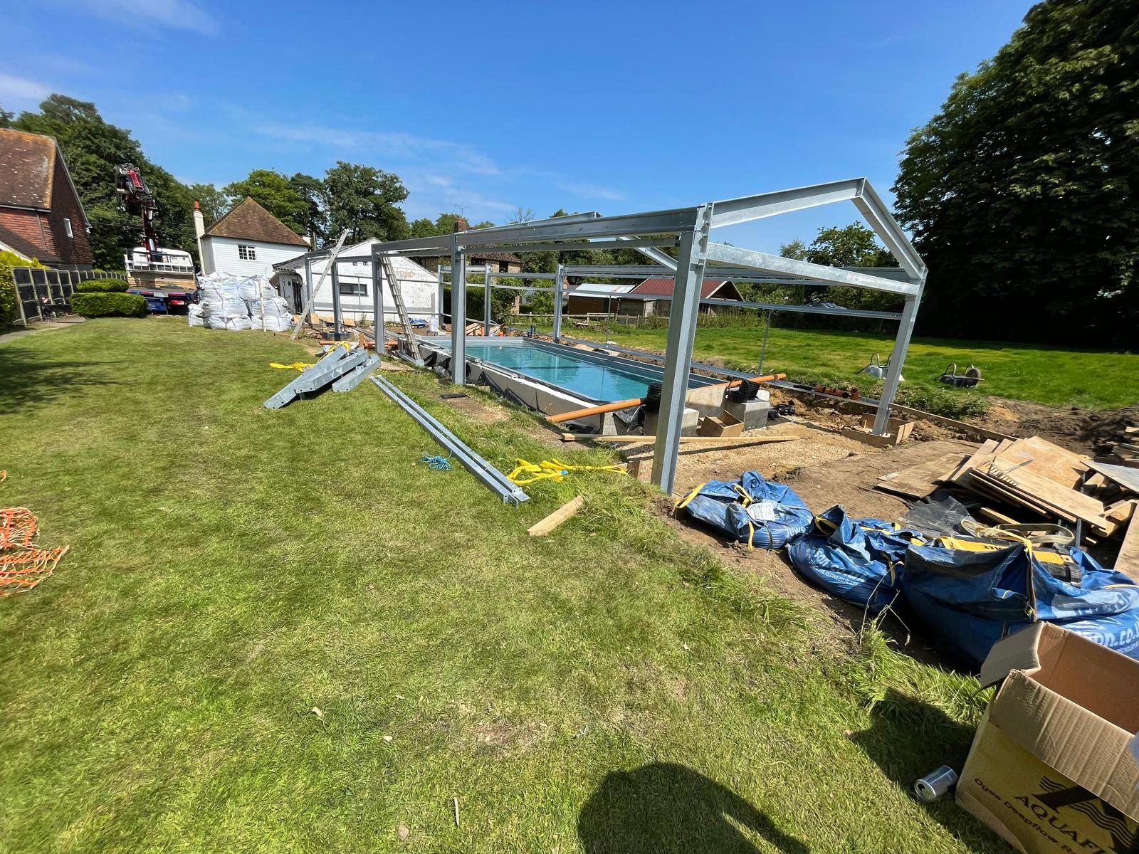 Metal framework for swimming pool with metal roof structure in place