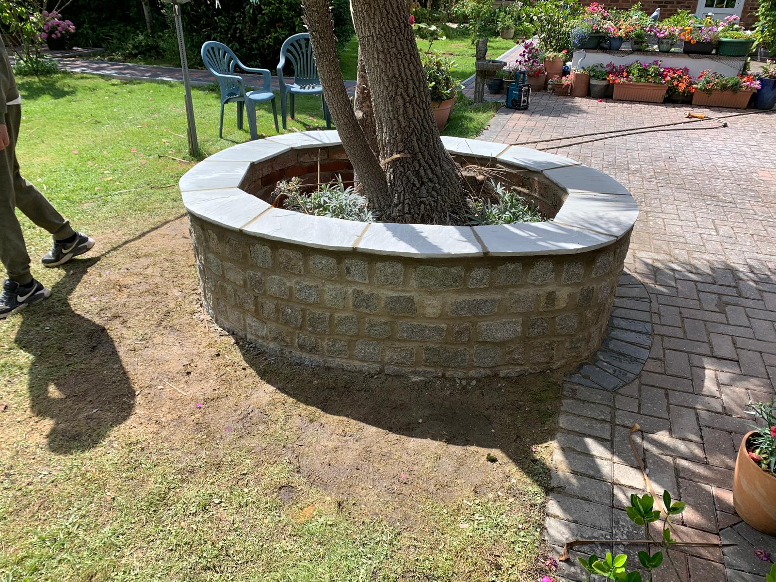 Natural stone circle wall installed with top slab around a tree for a landscaping project
