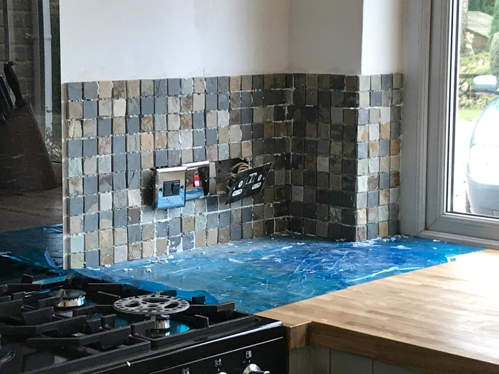 Natural stone mosaic wall tile installation round the corner