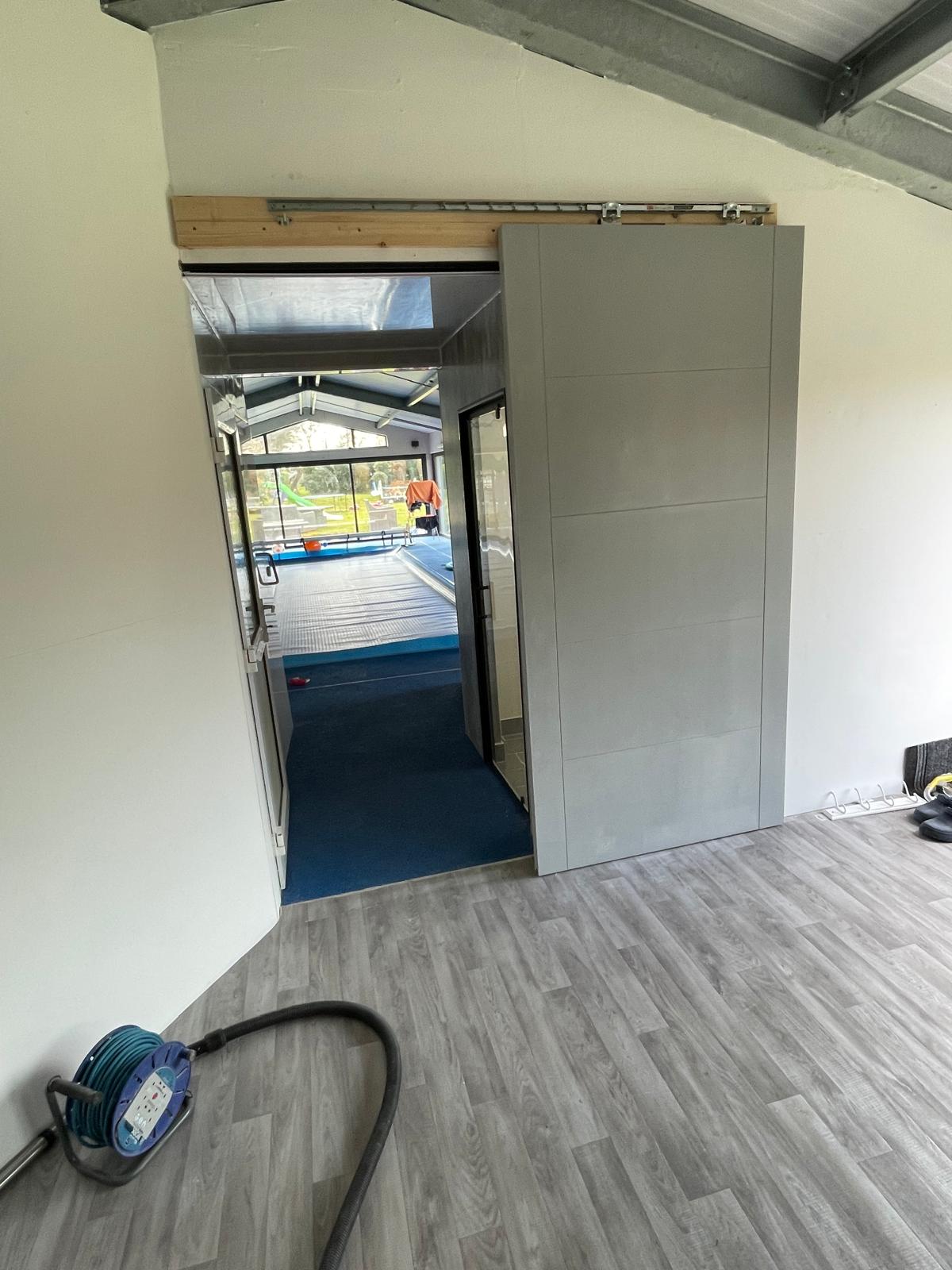 Partitions and doors being installed in swimming pool area