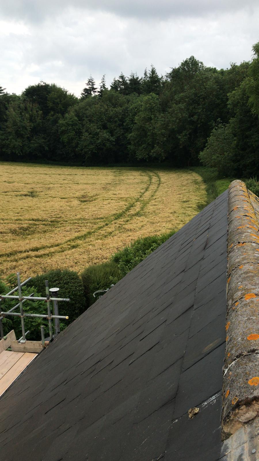 Ridge tile installation on slate roof