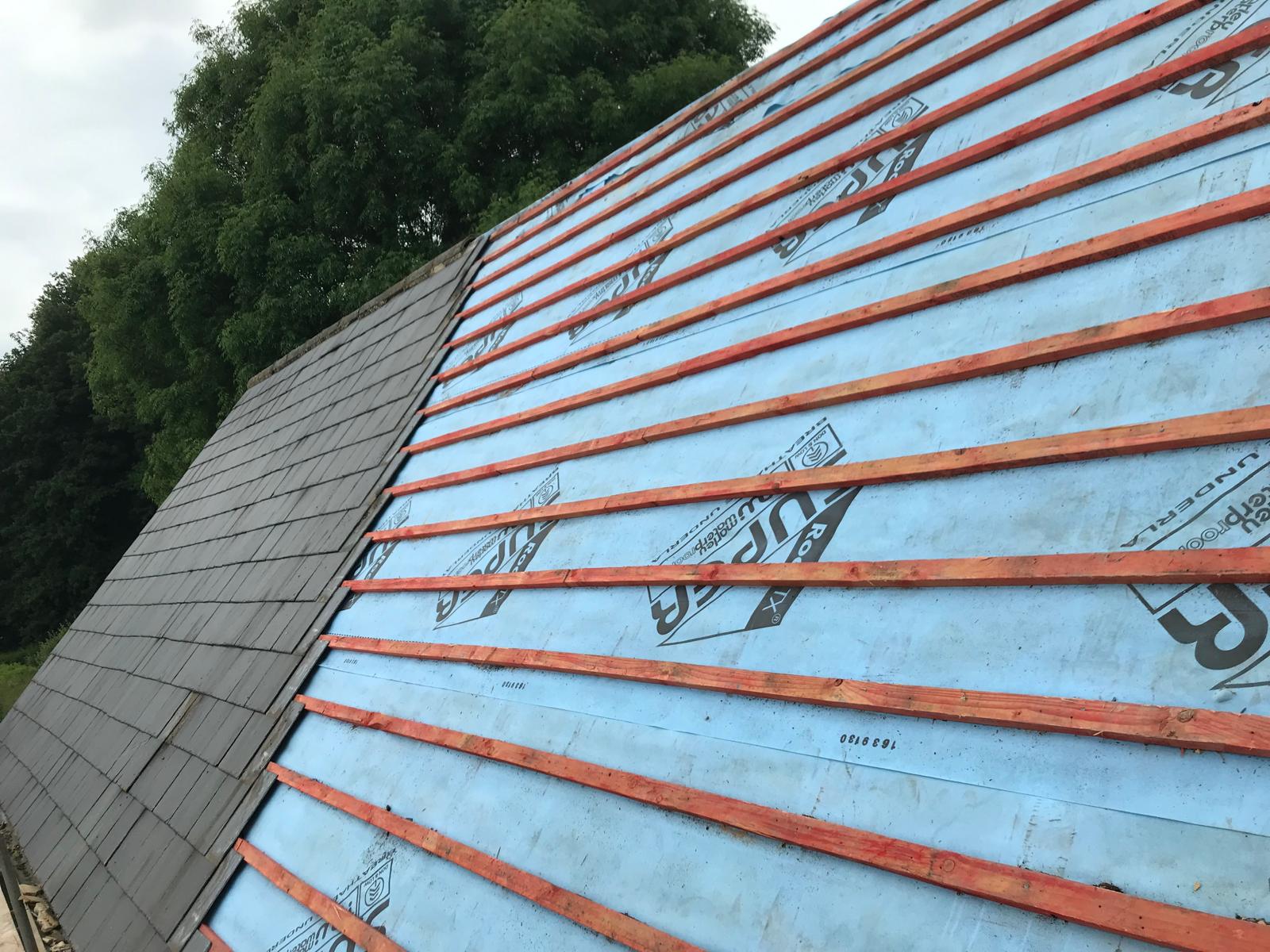 Roof project with slate roof tiles being installed