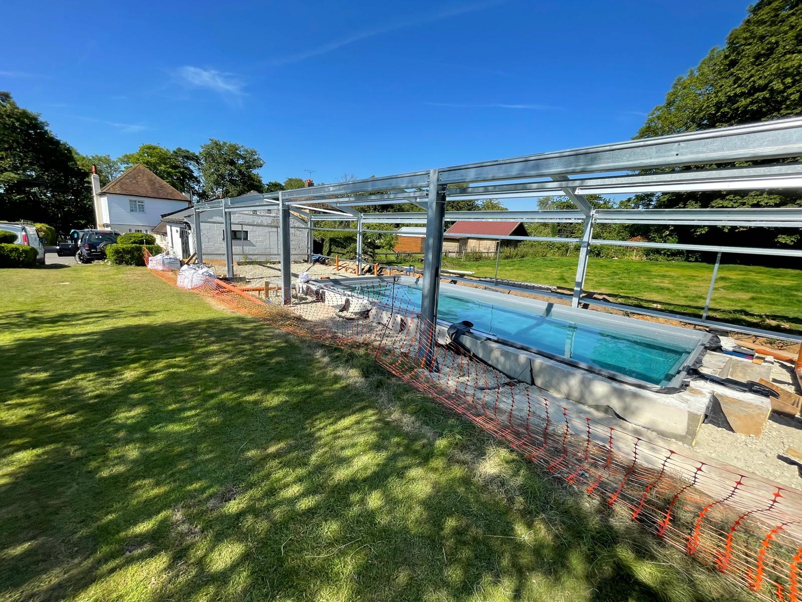 Side view of the metal framework being constructed around the swimming pool