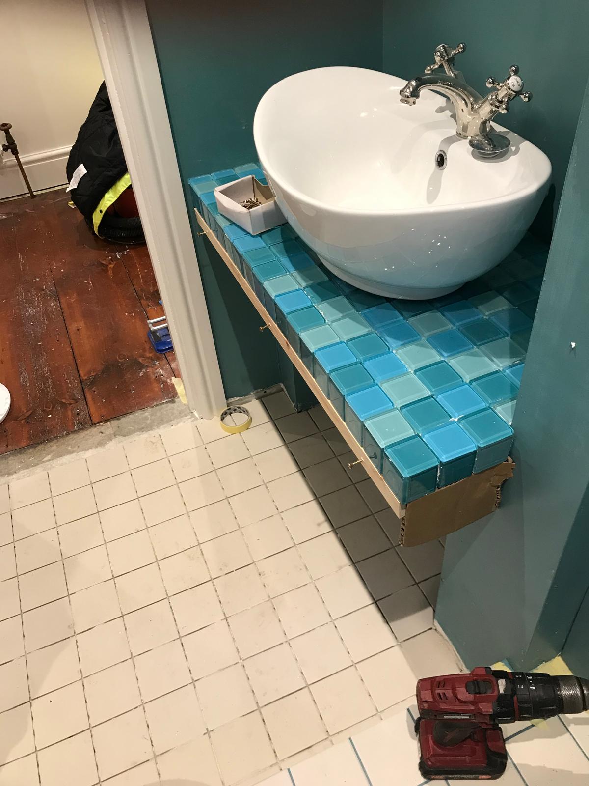 Sink installation on blue mosaic tiles on local bathroom project