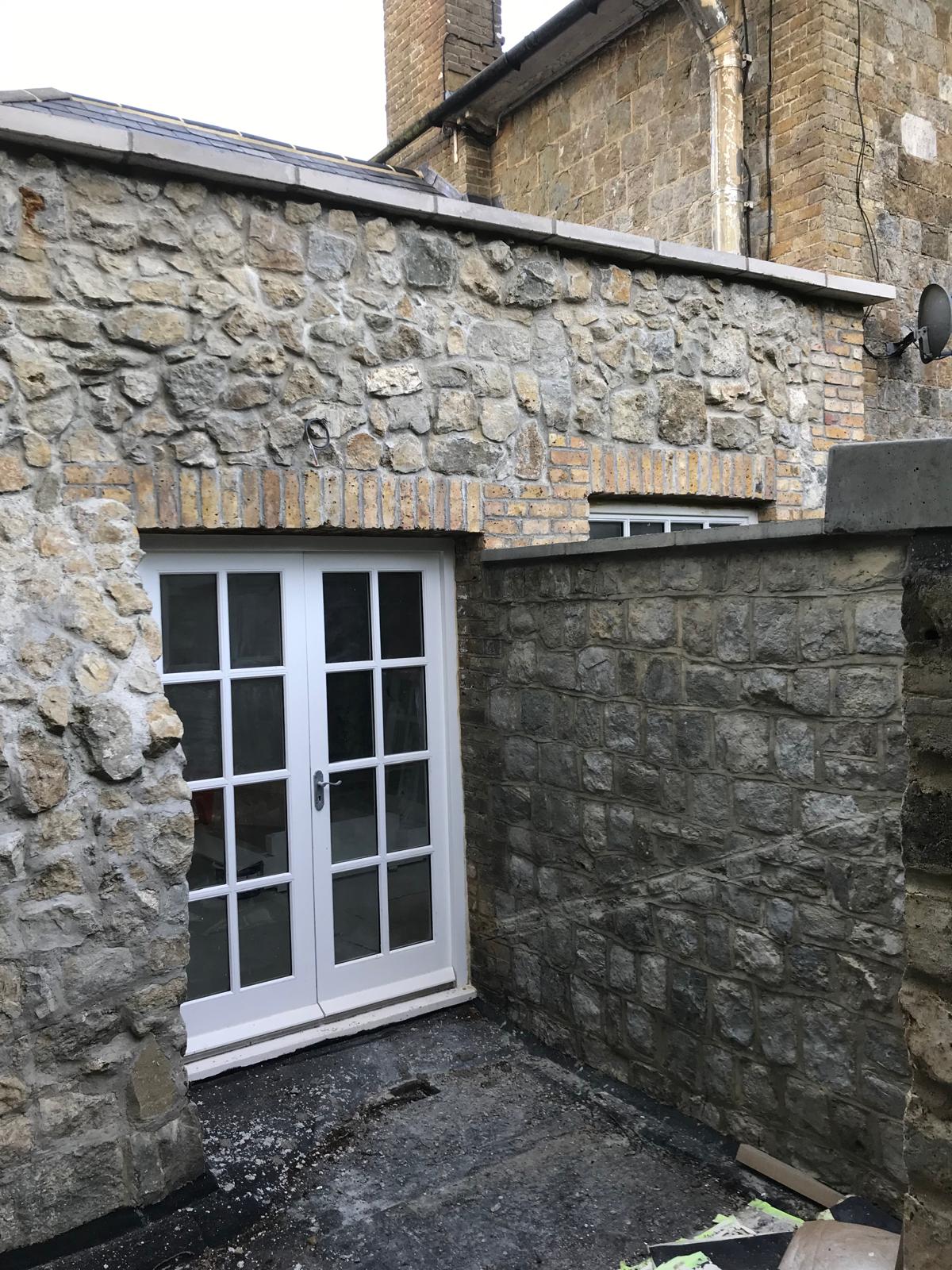 Slab installation around stone walls part of extension project