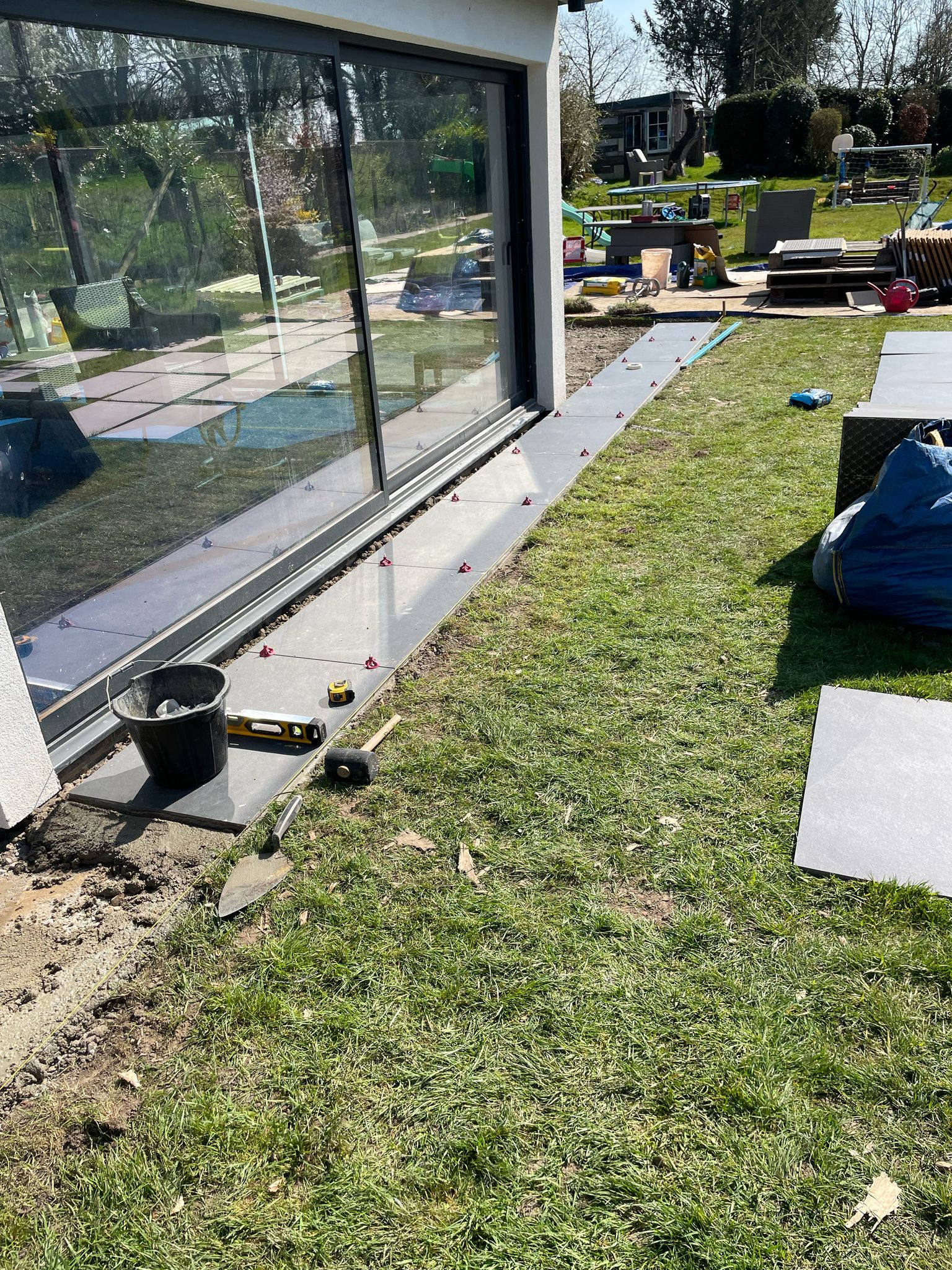 Slabs being laid around the side of the swimming pool building