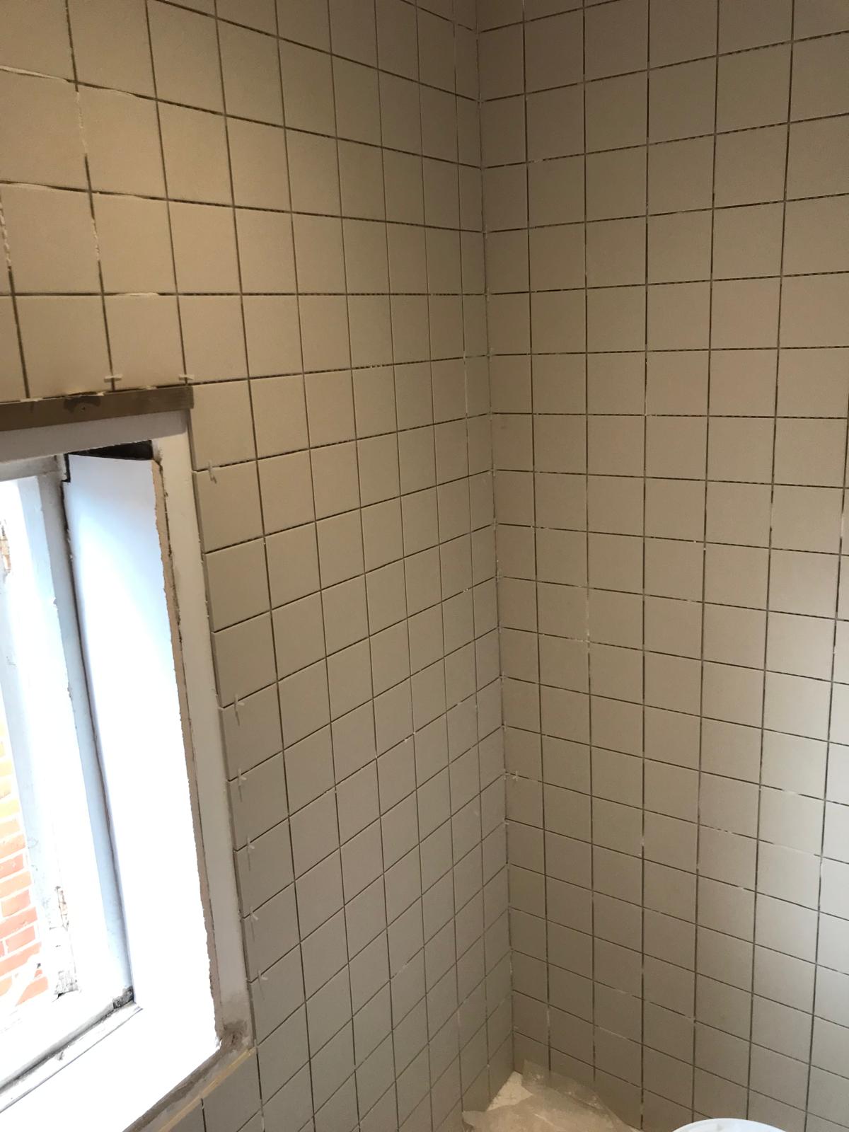 Square white wall tile installation on a bathroom project