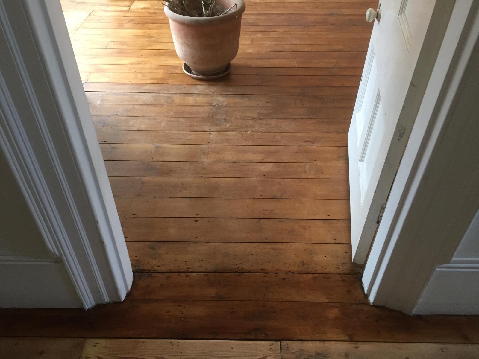 Stain application on a wooden floor around the door frame