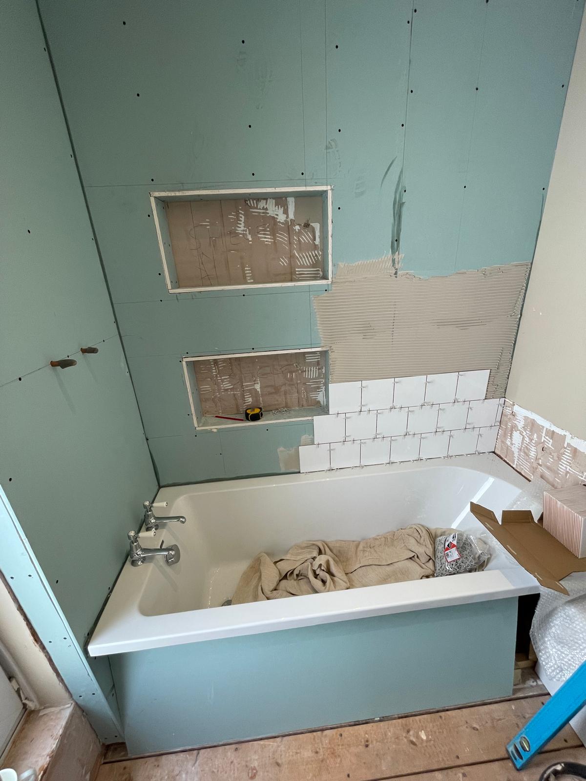 Start of white wall tile installation on bathroom re-fit project 1