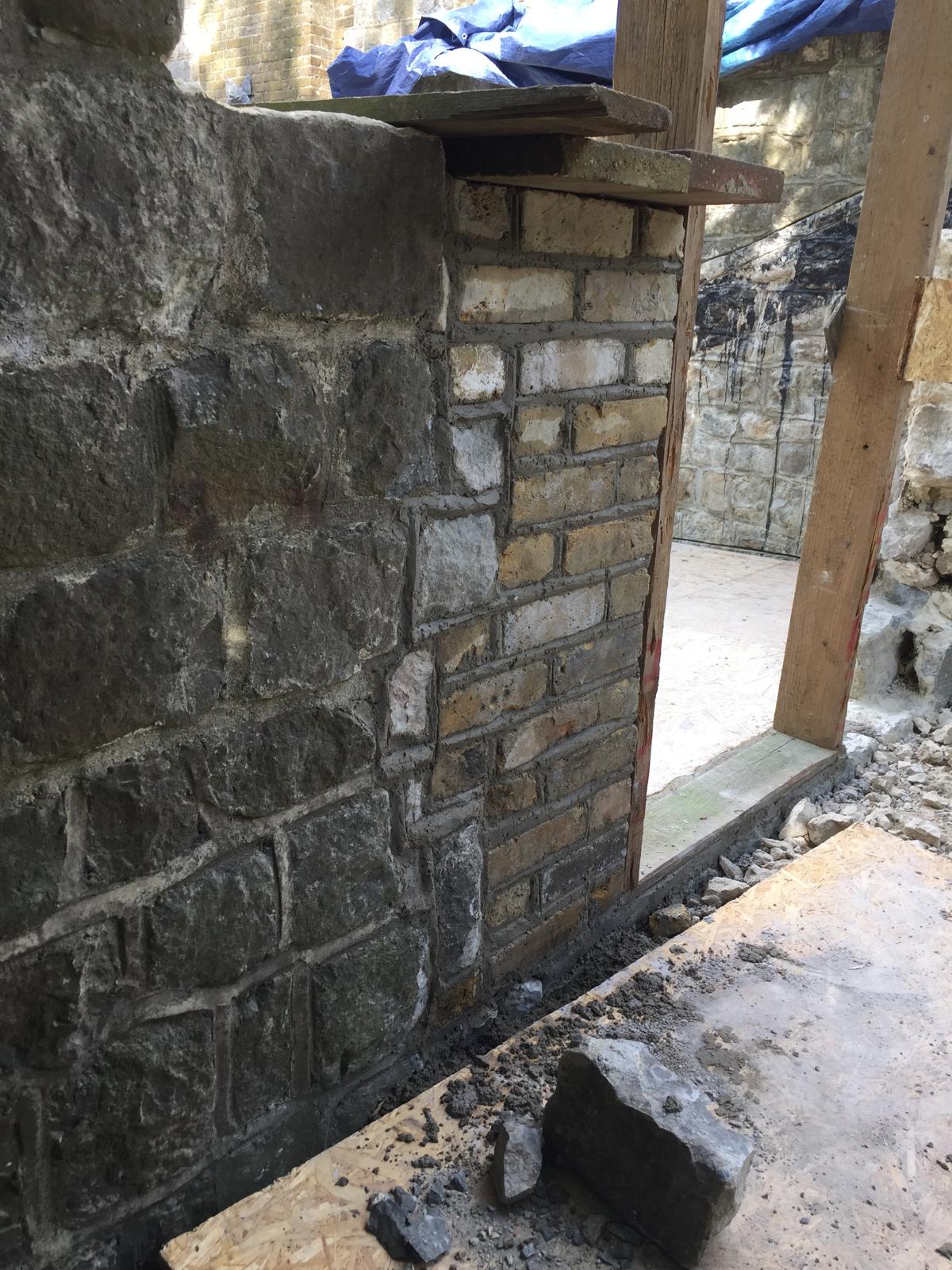 Stone and brick mix wall installation around door frame for local extension project