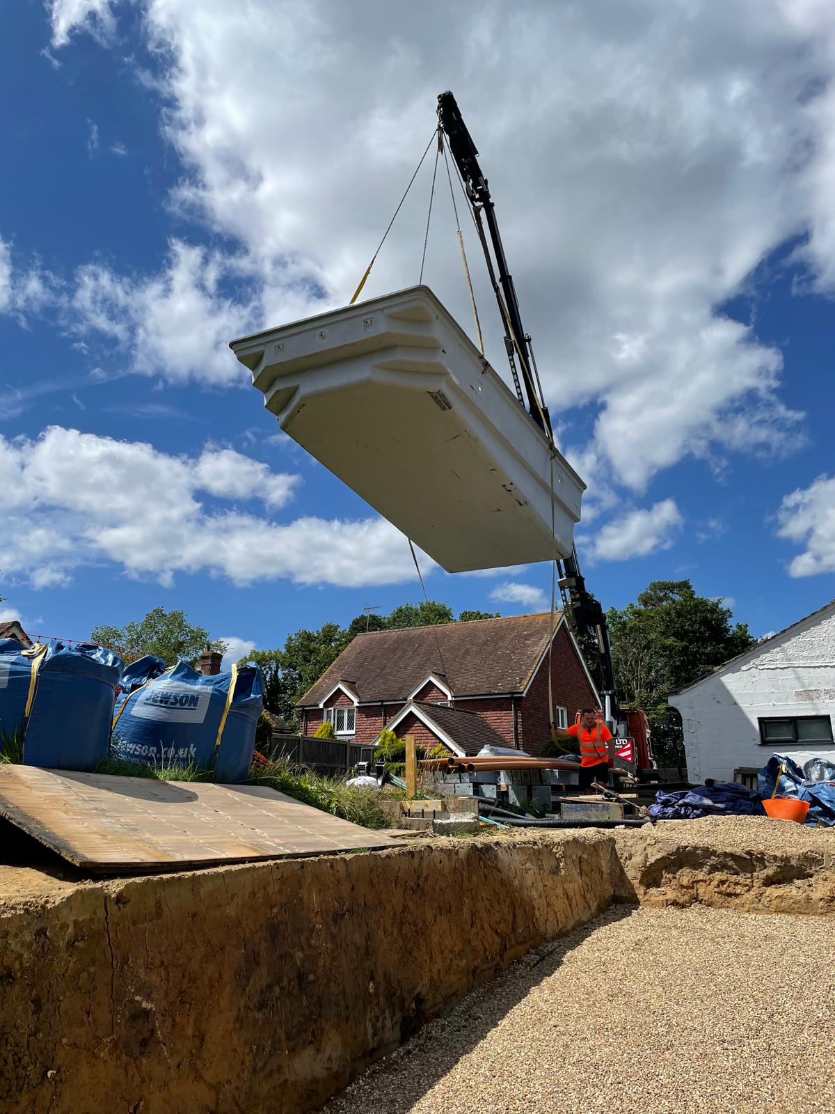 Swimming pool liner being craned inside the prepared area in Sellindge