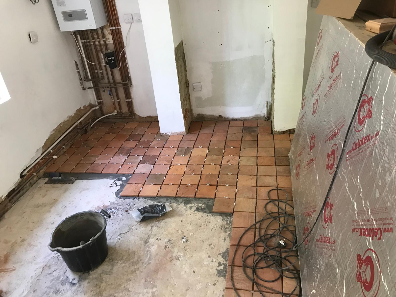 Terracotta floor tile installation around post