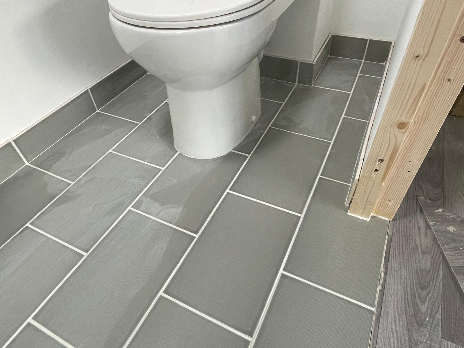 Toilet installed and grout applied for toilet area of swimming pool build
