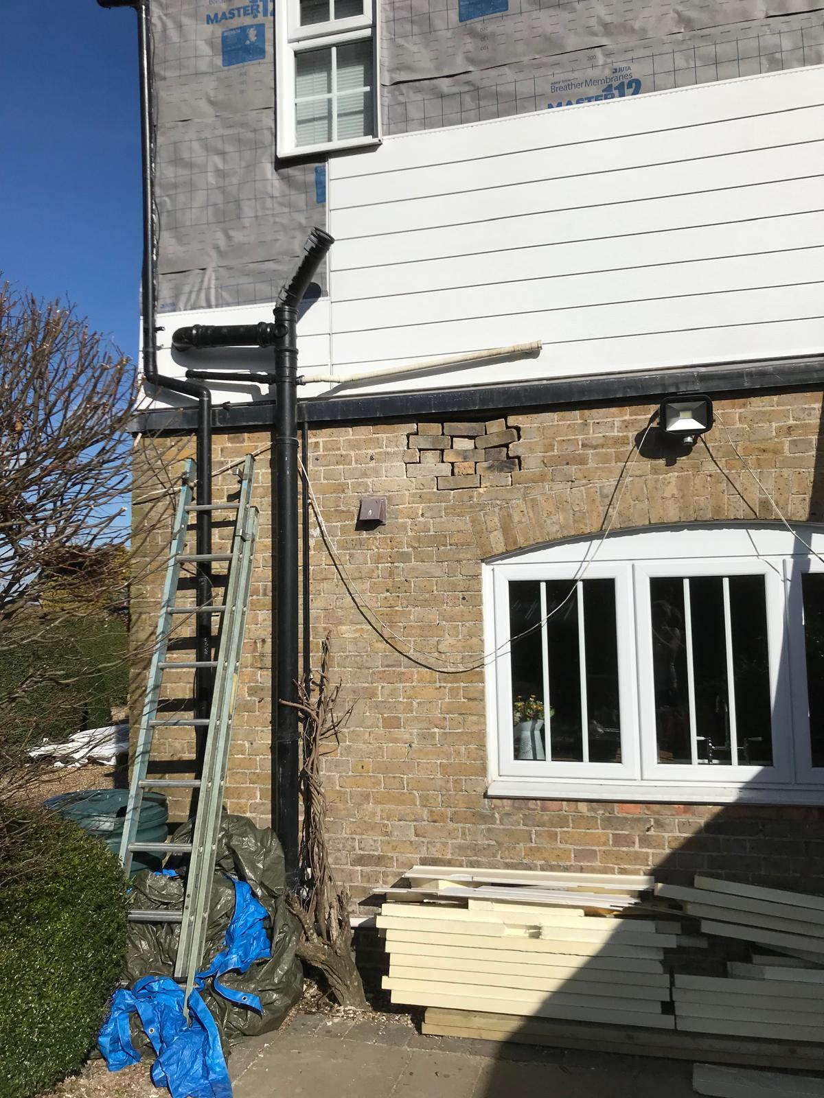 White cladding being installed on the side of a house