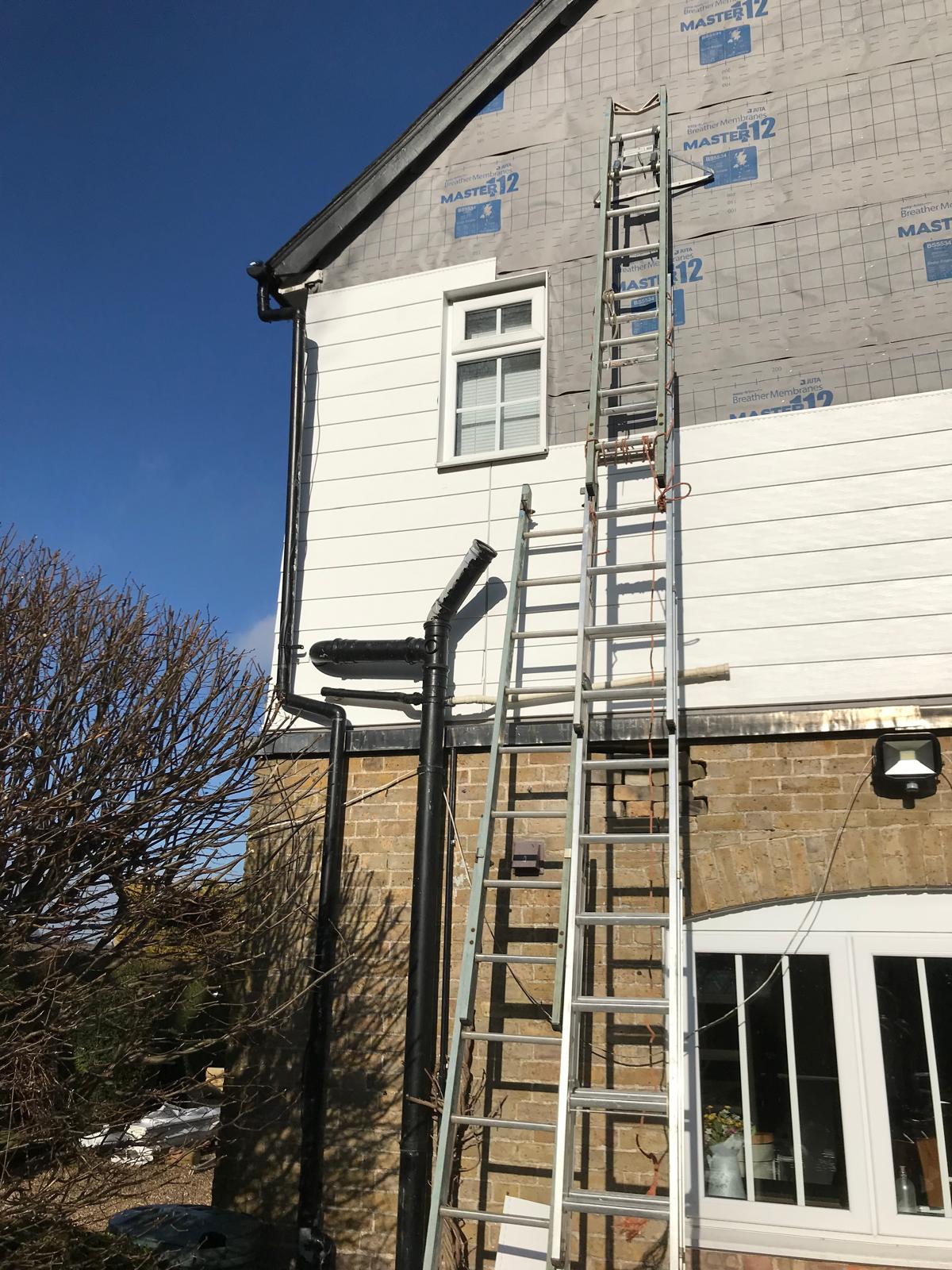 White cladding installation on side of house