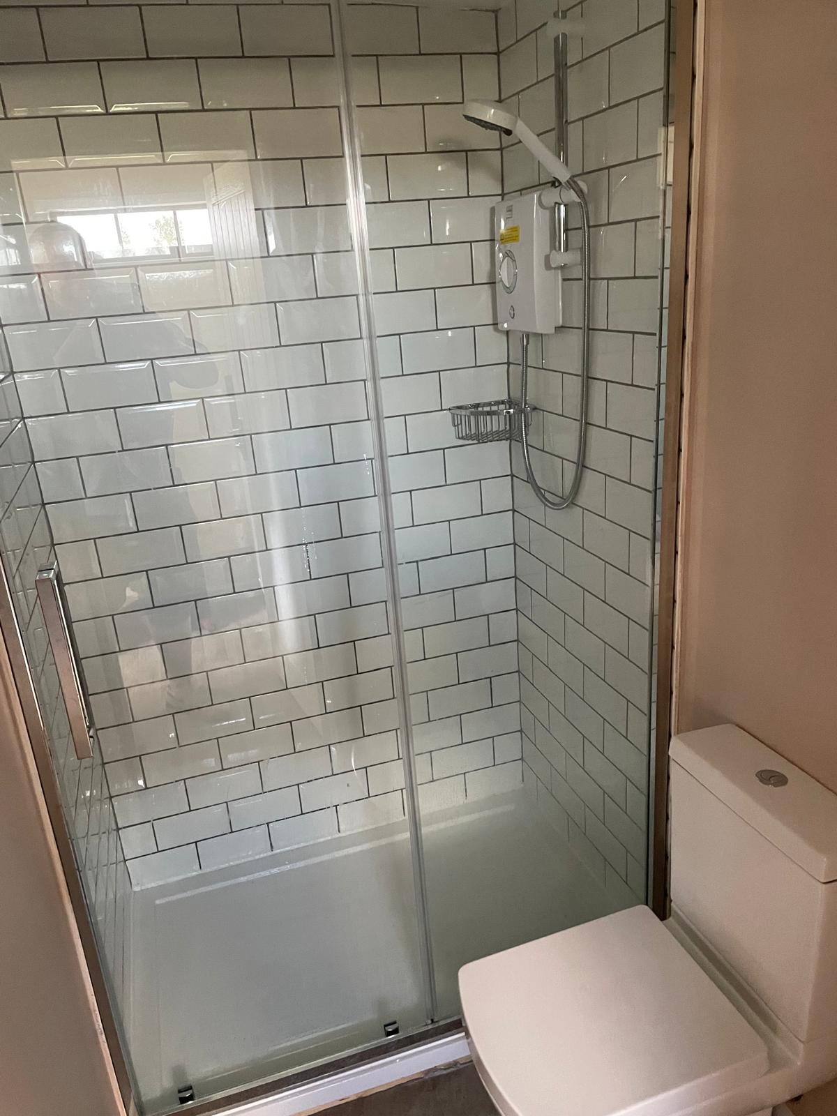 White tile installation in a shower encloser area for a local bathroom project 
