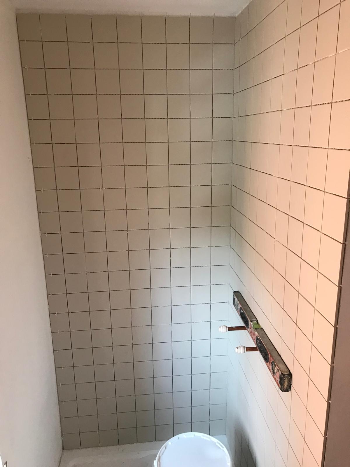 White tile installation in shower area 